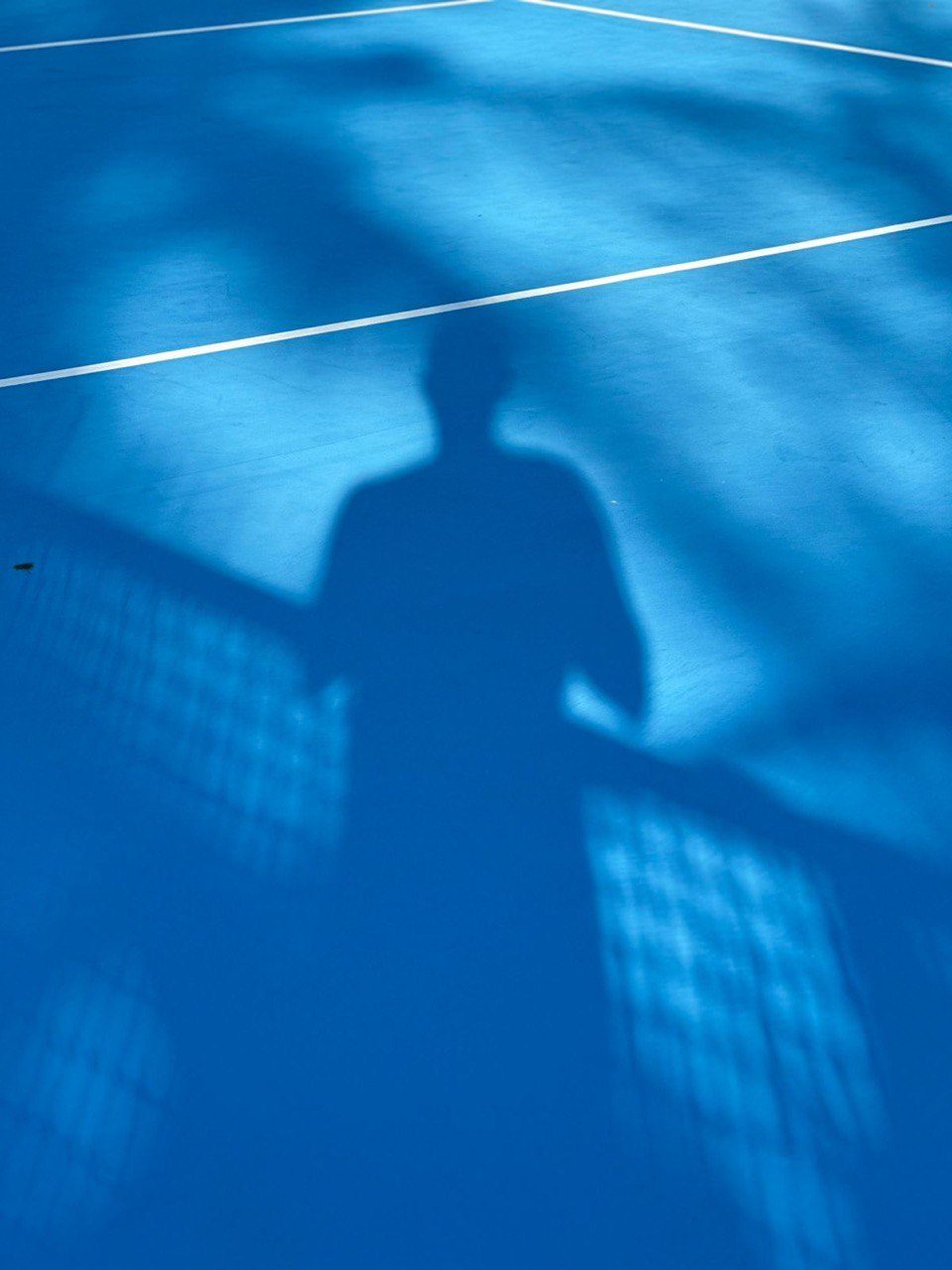 Player shadow on blue hard court