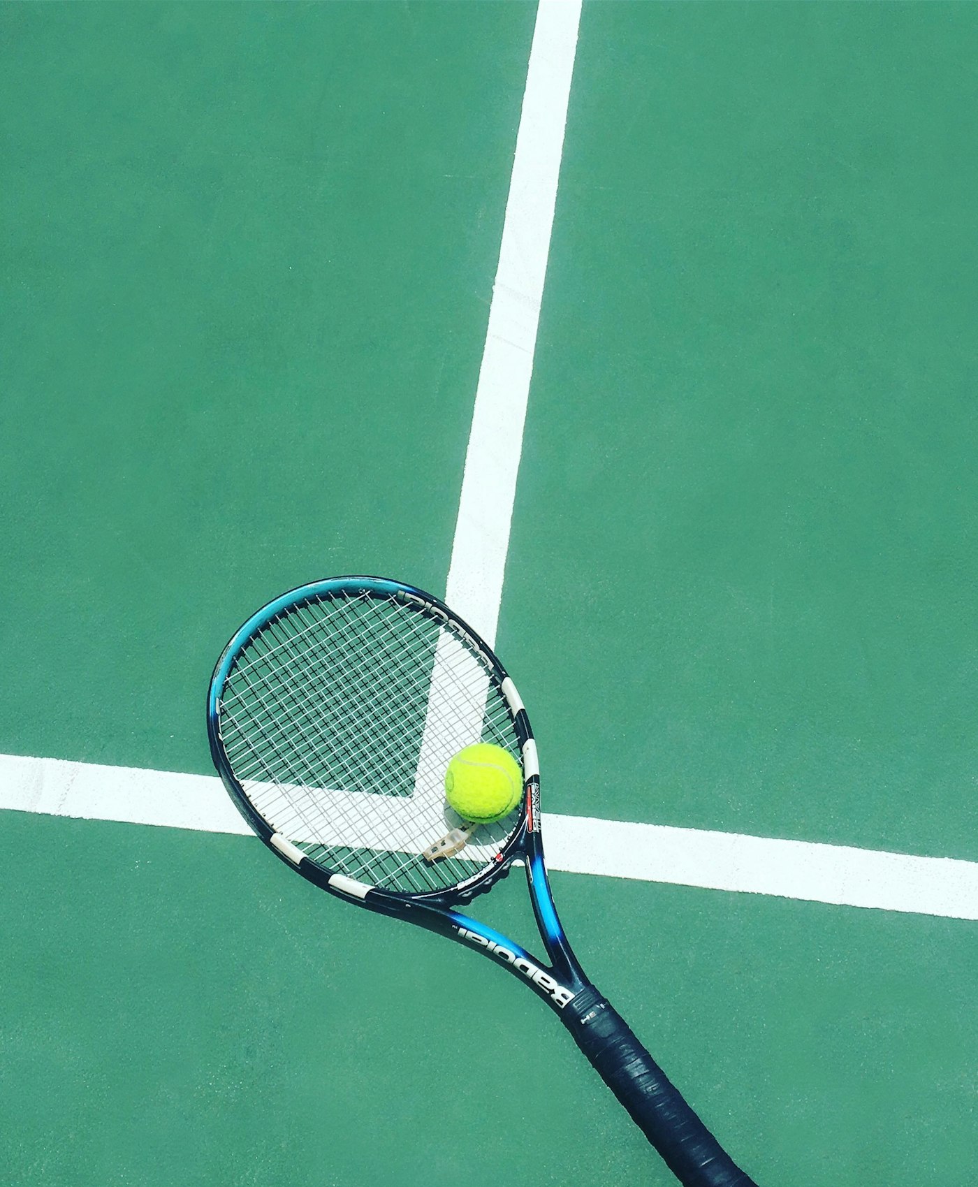 Tennis racquet and ball on court